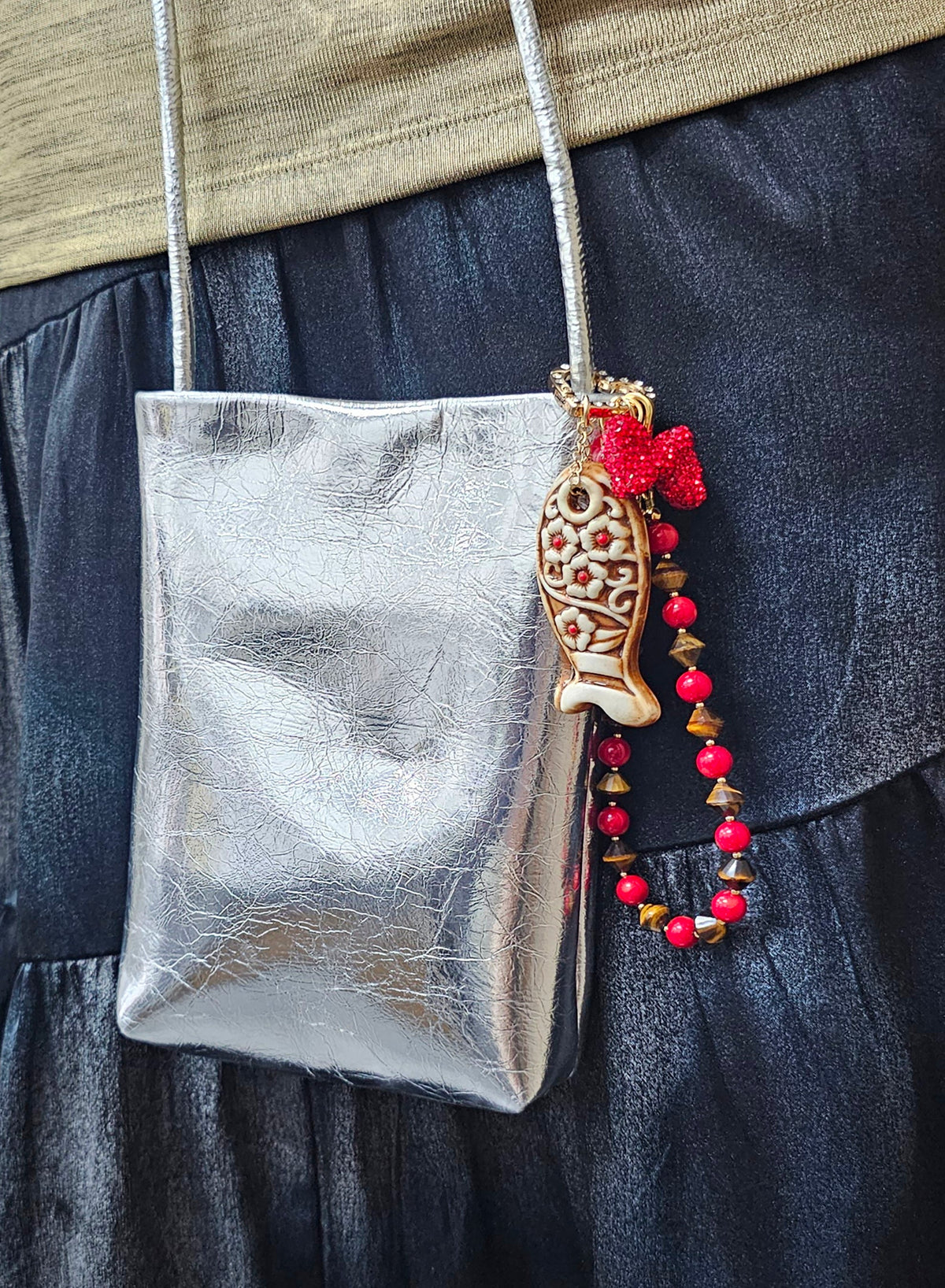Bijou de sac poisson en céramique Muta accroché à un sac
